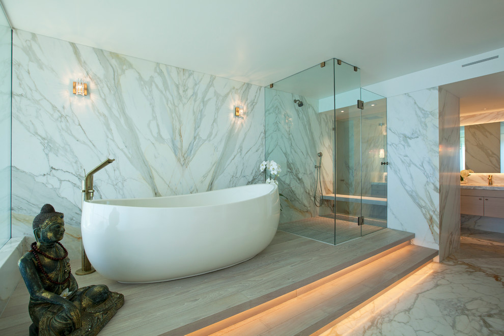 Inspiration för mycket stora moderna en-suite badrum, med släta luckor, skåp i ljust trä, ett fristående badkar, en kantlös dusch, vit kakel, marmorkakel, vita väggar, marmorgolv, marmorbänkskiva, vitt golv och dusch med gångjärnsdörr