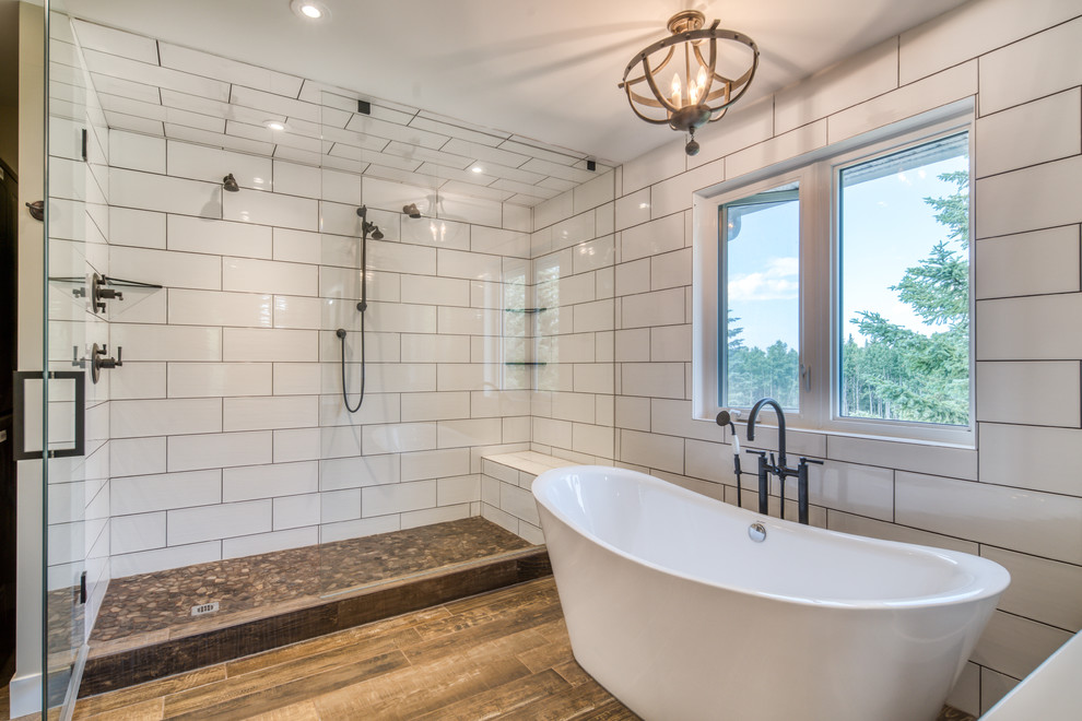 Photo of a small farmhouse ensuite bathroom in Calgary with freestanding cabinets, medium wood cabinets, a freestanding bath, a double shower, a one-piece toilet, white tiles, ceramic tiles, green walls, ceramic flooring, a trough sink, engineered stone worktops, brown floors, a hinged door and white worktops.