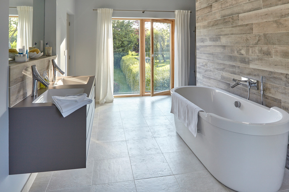 Idéer för ett stort modernt en-suite badrum, med ett fristående badkar, en öppen dusch, ett väggmonterat handfat, blå väggar och klinkergolv i keramik