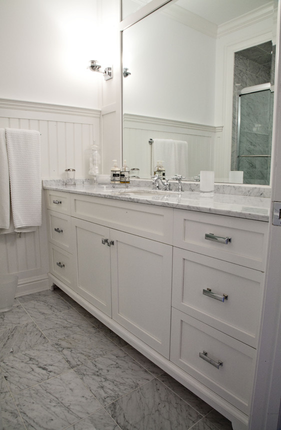Foto de cuarto de baño campestre de tamaño medio con armarios estilo shaker, puertas de armario blancas, lavabo bajoencimera, encimera de mármol, paredes blancas, suelo de baldosas de porcelana y suelo gris