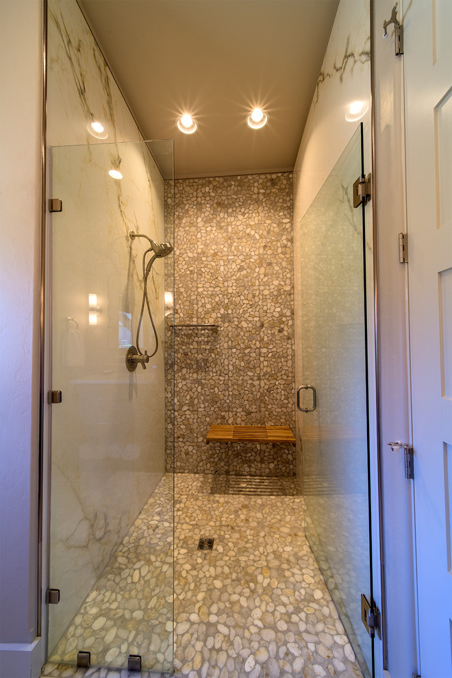 Cette image montre une salle d'eau design avec un espace douche bain, du carrelage en marbre, un sol en galet, un sol multicolore et une cabine de douche à porte battante.