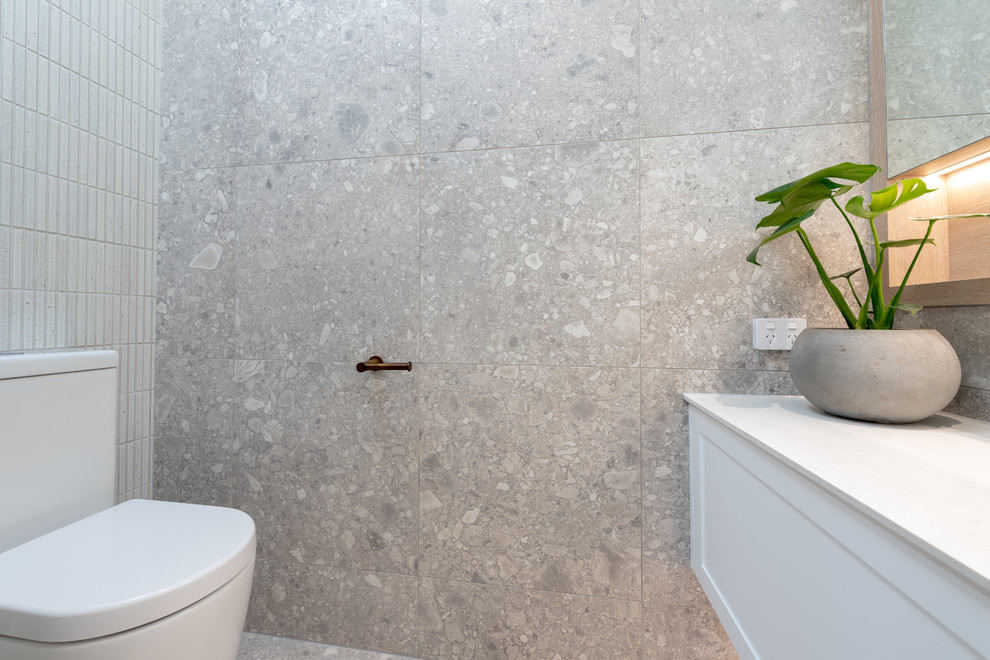 Источник вдохновения для домашнего уюта: большая главная ванная комната в современном стиле с фасадами в стиле шейкер, белыми фасадами, отдельно стоящей ванной, открытым душем, раздельным унитазом, серой плиткой, керамогранитной плиткой, серыми стенами, полом из керамогранита, настольной раковиной, столешницей из искусственного кварца, серым полом, открытым душем и белой столешницей