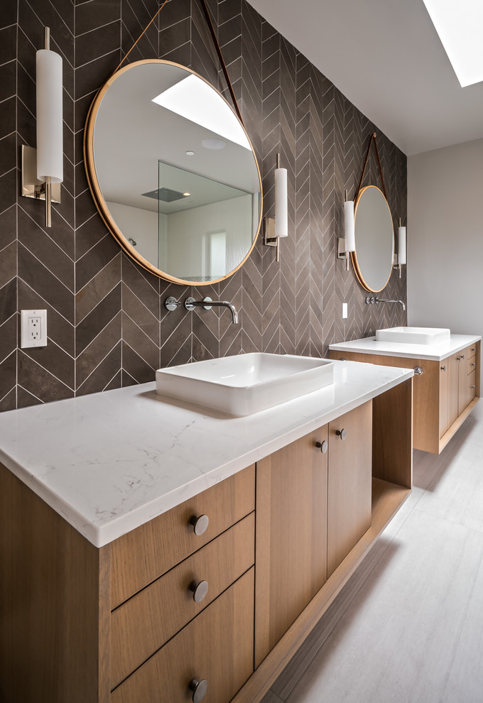 На фото: главная ванная комната в современном стиле с плоскими фасадами, фасадами цвета дерева среднего тона, коричневой плиткой, настольной раковиной, белым полом, белой столешницей и зеркалом с подсветкой с