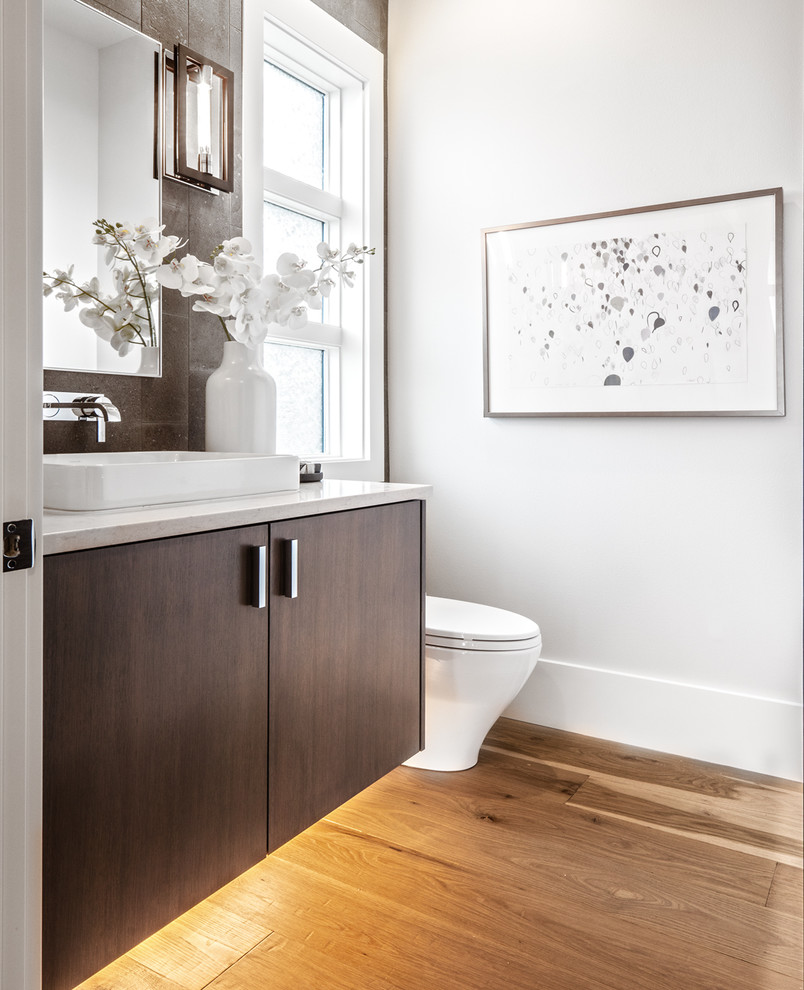 Immagine di una stanza da bagno contemporanea con ante lisce, ante in legno bruno, piastrelle marroni, pareti bianche, pavimento in legno massello medio, lavabo a bacinella, pavimento marrone e top bianco