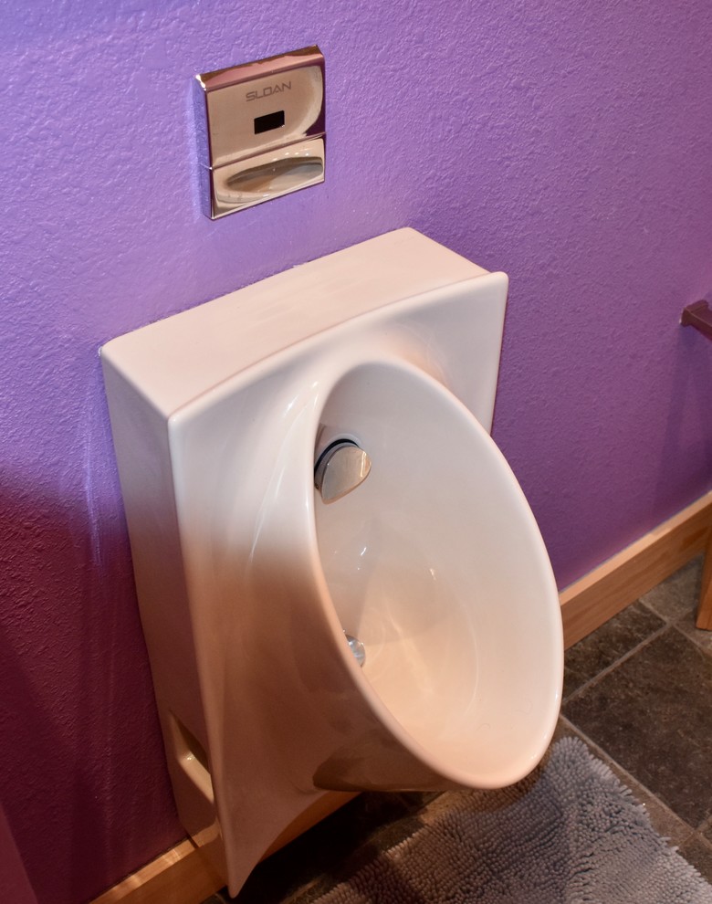 Imagen de cuarto de baño contemporáneo de tamaño medio con armarios con paneles lisos, ducha empotrada, urinario, paredes púrpuras, suelo de pizarra, lavabo sobreencimera, encimera de acrílico y ducha abierta