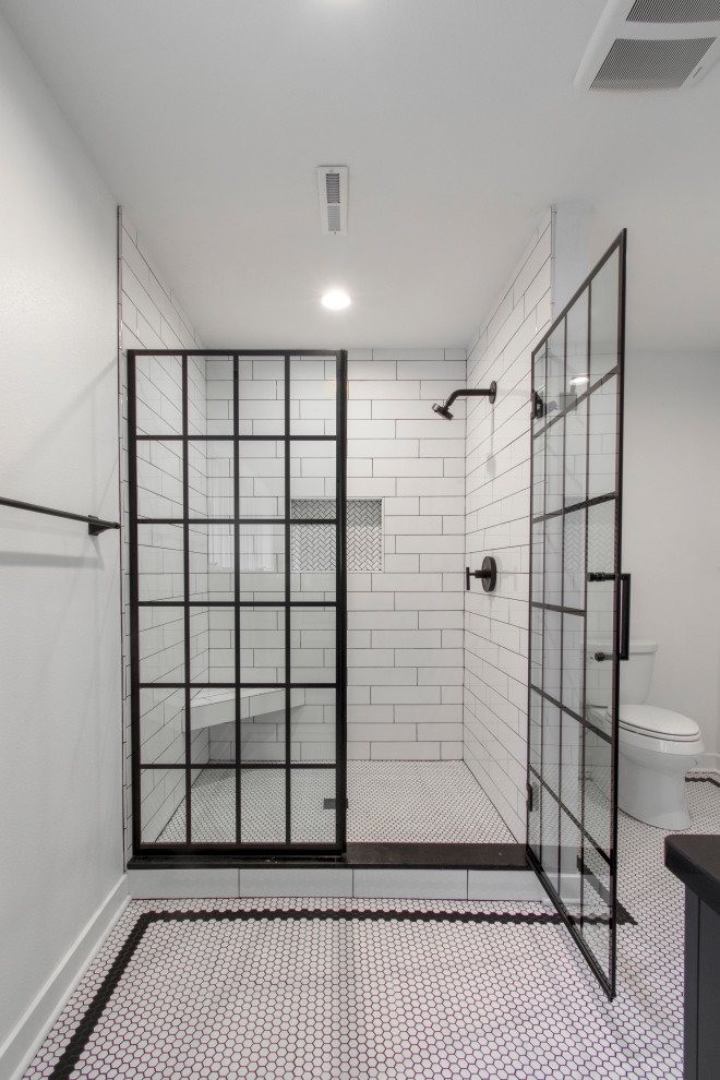 Exempel på ett stort modernt svart svart en-suite badrum, med släta luckor, svarta skåp, en kantlös dusch, en toalettstol med separat cisternkåpa, vit kakel, keramikplattor, vita väggar, klinkergolv i porslin, ett undermonterad handfat, bänkskiva i kvarts, vitt golv och dusch med gångjärnsdörr