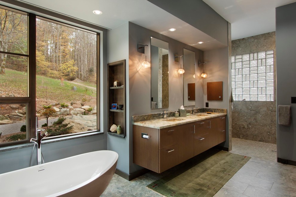 Example of a large trendy master brown tile and ceramic tile porcelain tile and brown floor bathroom design in Other with flat-panel cabinets, medium tone wood cabinets, an undermount sink, granite countertops, brown walls and a two-piece toilet