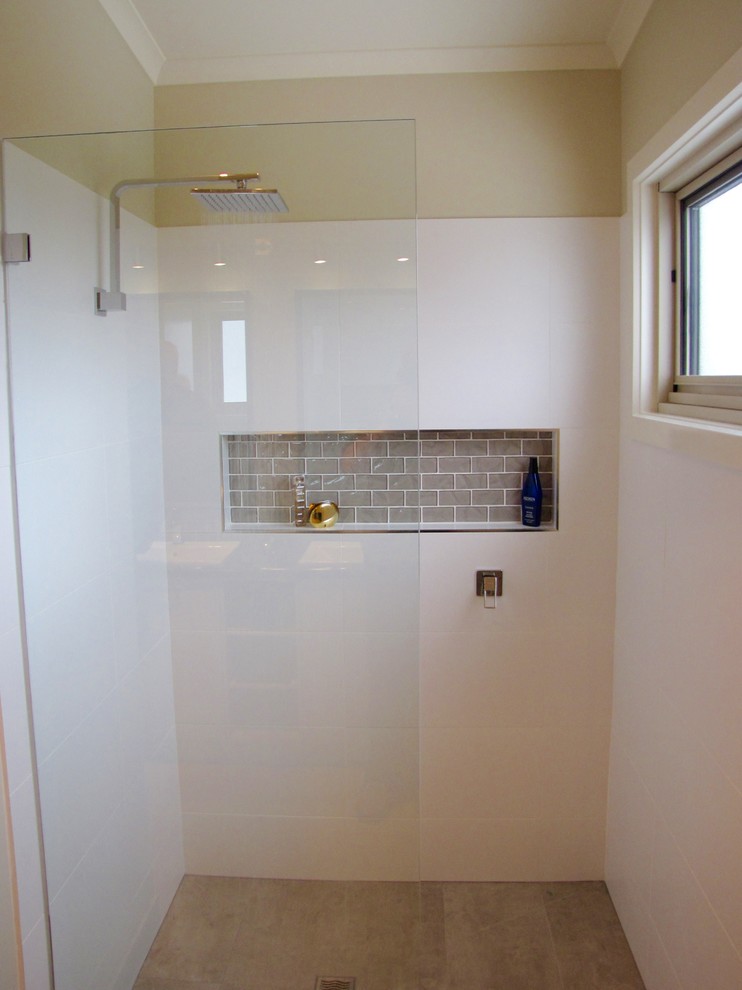 Photo of a medium sized contemporary ensuite bathroom in Melbourne with shaker cabinets, beige cabinets, a freestanding bath, a walk-in shower, a one-piece toilet, beige walls, ceramic flooring, a built-in sink, laminate worktops, grey tiles and glass tiles.