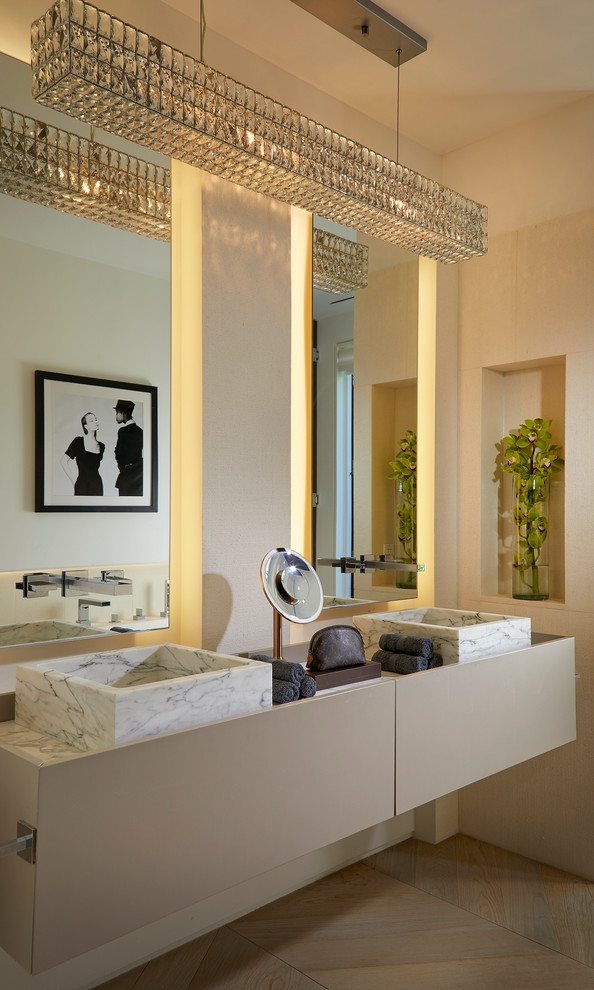 Modelo de cuarto de baño principal marinero con armarios con paneles lisos, puertas de armario beige, suelo de madera clara, lavabo sobreencimera y suelo beige