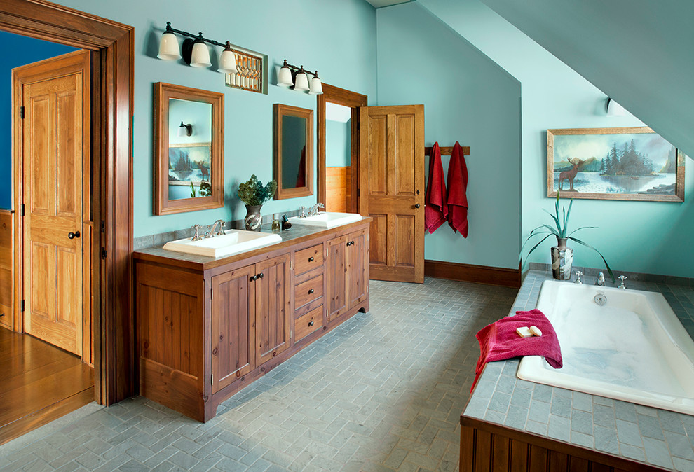 На фото: ванная комната в классическом стиле с фасадами с декоративным кантом, фасадами цвета дерева среднего тона, накладной ванной, угловым душем, зеленой плиткой, каменной плиткой, зелеными стенами, полом из сланца, накладной раковиной и столешницей из плитки с