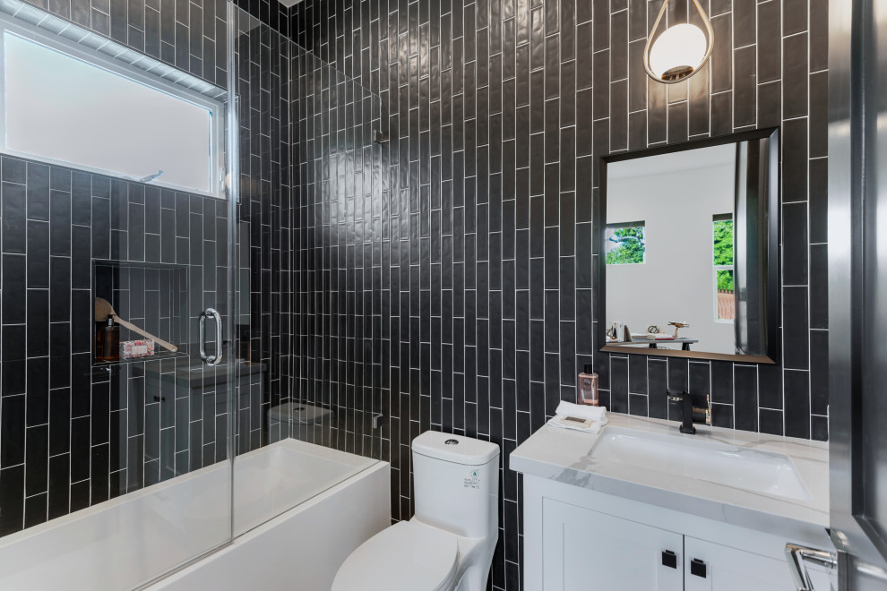 Bild på ett mellanstort funkis grå grått badrum med dusch, med skåp i shakerstil, vita skåp, ett badkar i en alkov, en dusch/badkar-kombination, en toalettstol med hel cisternkåpa, grå kakel, tunnelbanekakel och ett undermonterad handfat