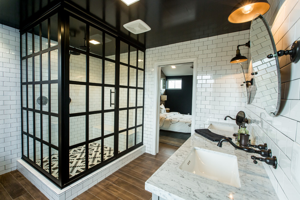 Inspiration for an industrial master black and white tile and subway tile medium tone wood floor corner shower remodel in DC Metro with white walls and an undermount sink