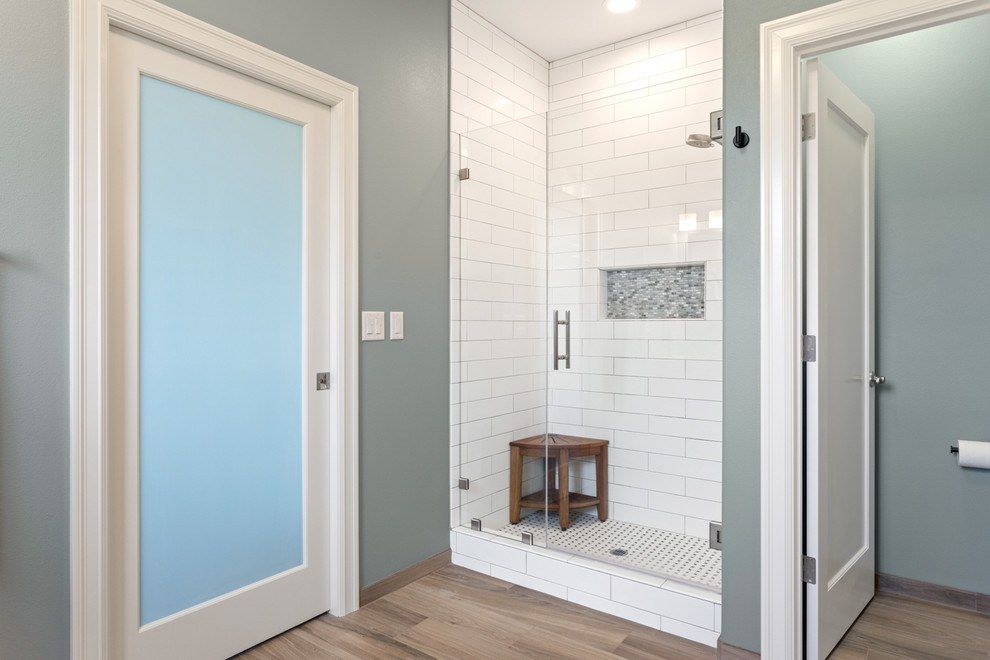 Ispirazione per una stanza da bagno padronale design di medie dimensioni con doccia alcova, piastrelle blu, pareti blu, pavimento con piastrelle in ceramica, pavimento marrone e porta doccia a battente