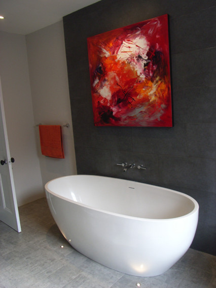 Foto på ett mellanstort funkis badrum med dusch, med ett fristående badkar, grå kakel, porslinskakel, grå väggar och linoleumgolv