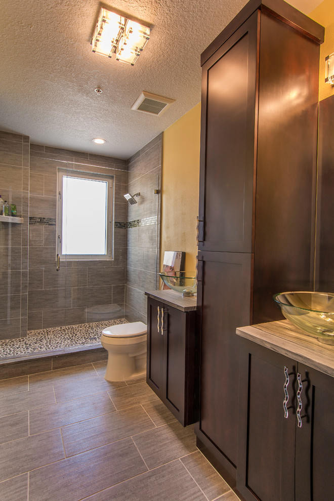 Doorless shower - large contemporary kids' gray tile and porcelain tile porcelain tile doorless shower idea in Tampa with a vessel sink, flat-panel cabinets, dark wood cabinets, granite countertops, a one-piece toilet and yellow walls