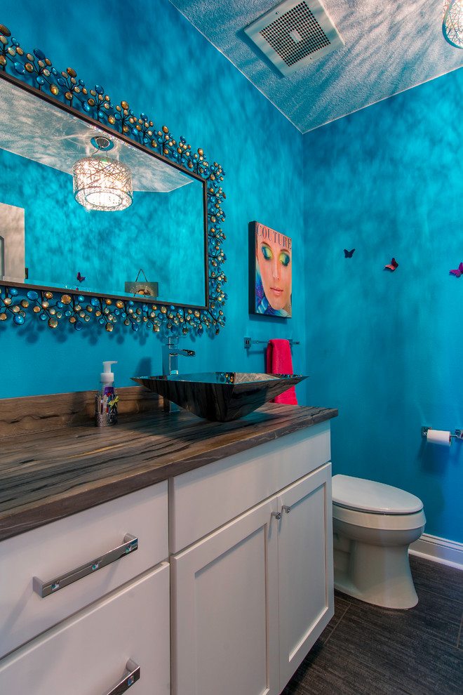 Ejemplo de cuarto de baño contemporáneo de tamaño medio con lavabo sobreencimera, armarios estilo shaker, puertas de armario blancas, encimera de granito, sanitario de una pieza, baldosas y/o azulejos grises, baldosas y/o azulejos de porcelana, paredes azules, suelo de baldosas de porcelana y aseo y ducha