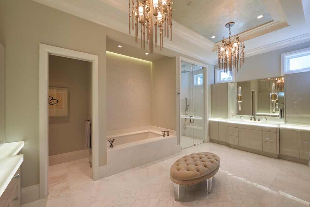 Стильный дизайн: огромная главная ванная комната в современном стиле с фасадами с утопленной филенкой, бежевыми фасадами, ванной в нише, угловым душем, унитазом-моноблоком, белой плиткой, плиткой мозаикой, бежевыми стенами, мраморным полом, монолитной раковиной и стеклянной столешницей - последний тренд