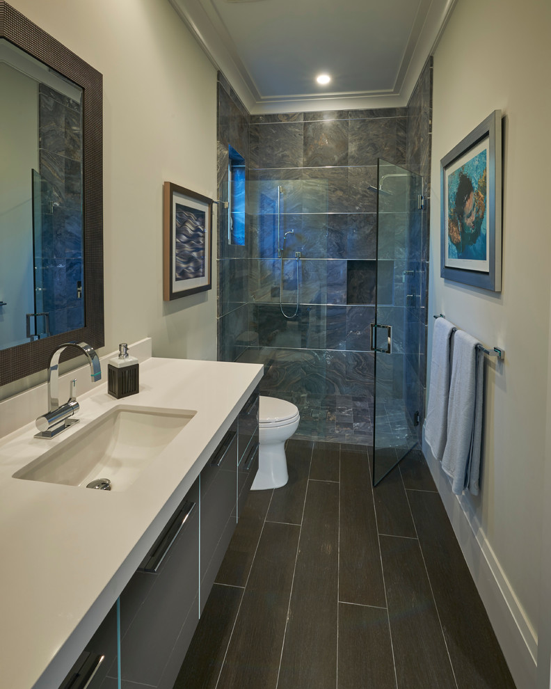 Inredning av ett modernt mellanstort badrum med dusch, med släta luckor, grå skåp, en dusch i en alkov, en toalettstol med hel cisternkåpa, svart och vit kakel, stenkakel, beige väggar, klinkergolv i keramik, ett väggmonterat handfat och bänkskiva i kvartsit