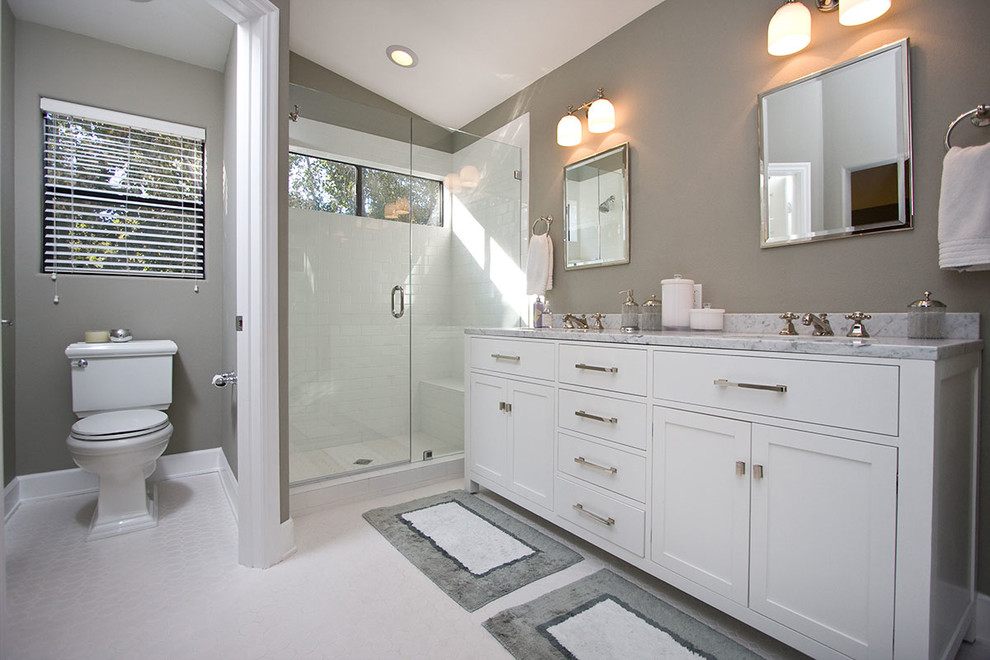 Aménagement d'une salle de bain grise et blanche contemporaine de taille moyenne avec un lavabo encastré, un placard à porte shaker, des portes de placard blanches, un plan de toilette en marbre, une douche d'angle, WC séparés, un carrelage blanc, un carrelage métro et un mur gris.