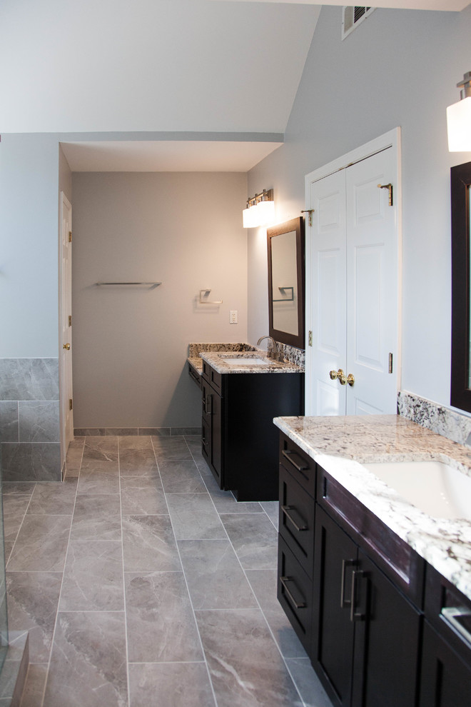 Design ideas for a medium sized contemporary ensuite bathroom in Atlanta with shaker cabinets, dark wood cabinets, a freestanding bath, a walk-in shower, a two-piece toilet, grey tiles, porcelain tiles, grey walls, porcelain flooring, a submerged sink, granite worktops, grey floors and a hinged door.