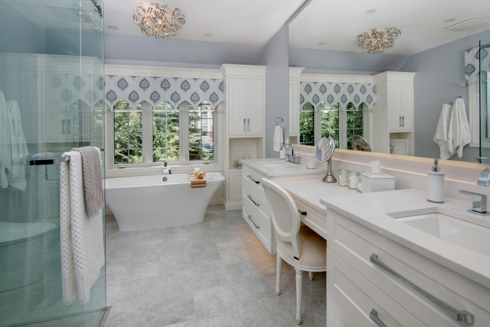 Exemple d'une grande salle de bain principale tendance avec un placard à porte shaker, des portes de placard blanches, une baignoire indépendante, une douche à l'italienne, WC à poser, un carrelage gris, des carreaux de porcelaine, un mur bleu, un sol en carrelage de porcelaine, un lavabo encastré, un plan de toilette en quartz modifié, un sol gris et une cabine de douche à porte coulissante.