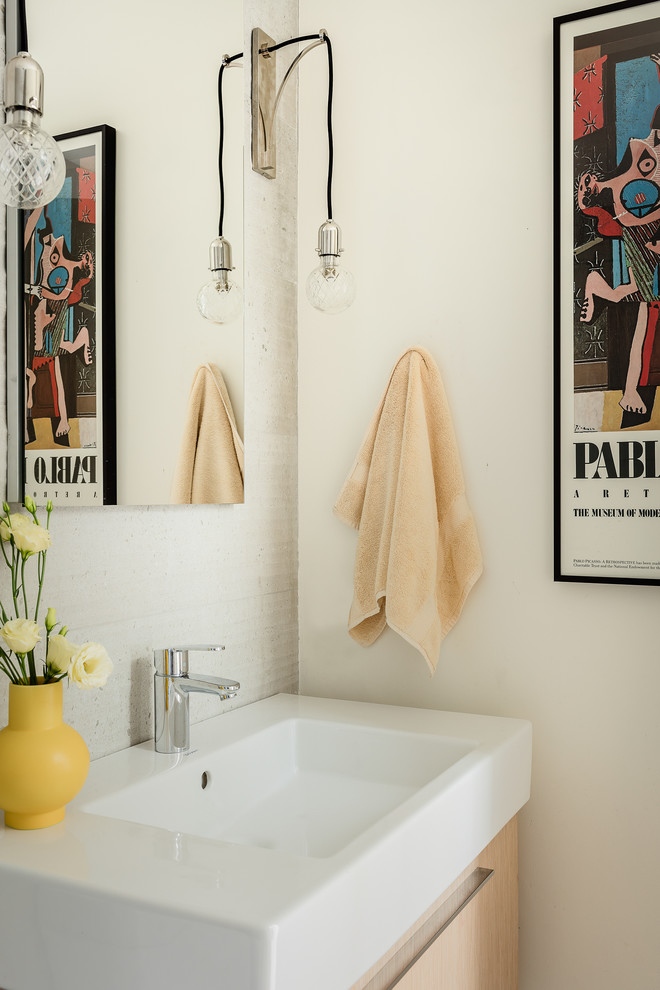 Ejemplo de cuarto de baño único y flotante actual con lavabo integrado, encimeras blancas, armarios con paneles lisos, puertas de armario de madera clara y paredes blancas