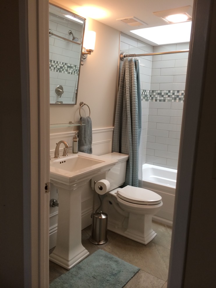 Immagine di una piccola stanza da bagno contemporanea con lavabo a colonna, vasca/doccia, WC a due pezzi, pareti blu e pavimento in travertino