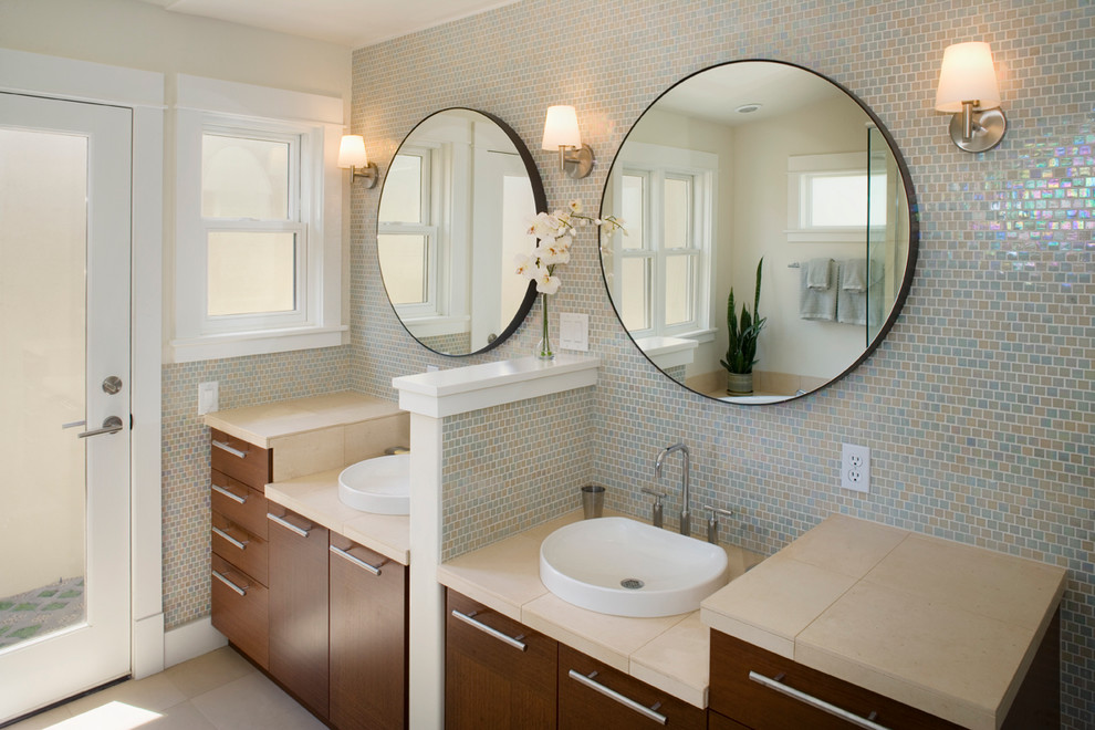 Immagine di una stanza da bagno contemporanea con lavabo a bacinella, ante lisce, ante in legno bruno, piastrelle blu e piastrelle a mosaico