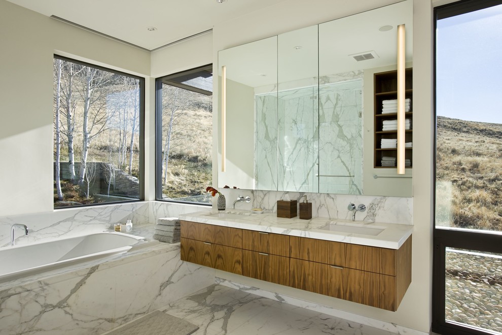 Idee per una stanza da bagno minimal con lavabo sottopiano, ante lisce, ante in legno scuro, vasca da incasso, piastrelle bianche e pareti bianche