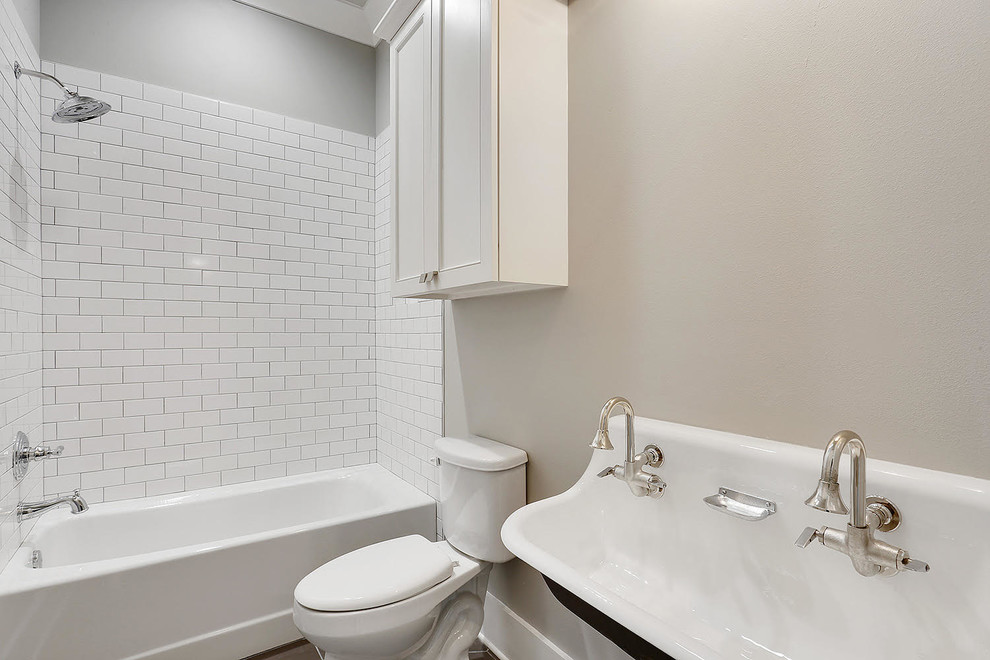 Medium sized contemporary shower room bathroom in New Orleans with recessed-panel cabinets, white cabinets, an alcove bath, a shower/bath combination, a two-piece toilet, white tiles, metro tiles, grey walls, a trough sink, solid surface worktops and a shower curtain.