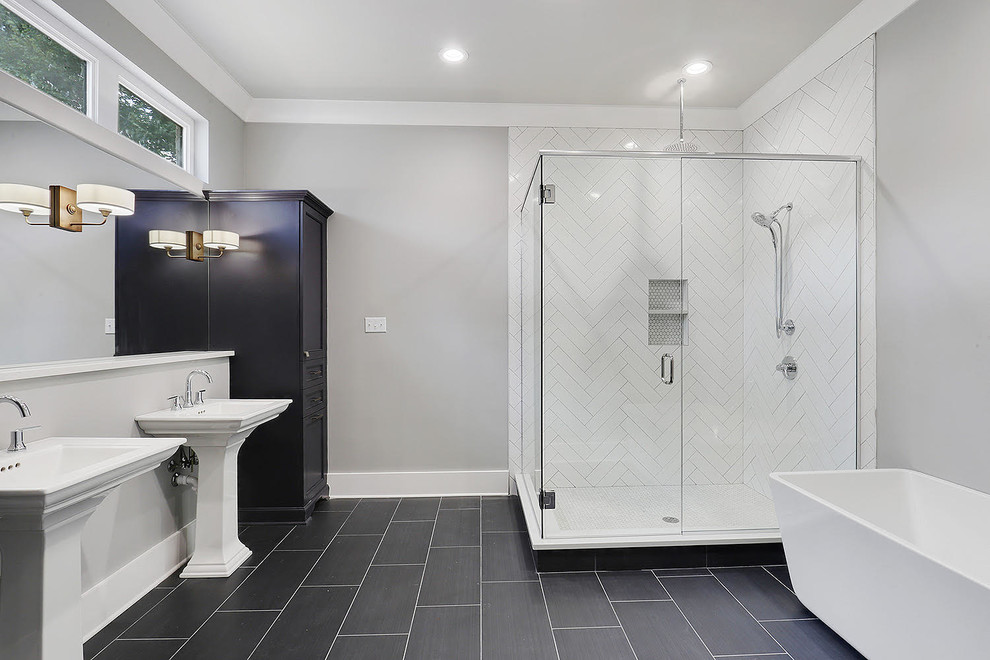 This is an example of a medium sized contemporary ensuite bathroom in New Orleans with recessed-panel cabinets, black cabinets, a freestanding bath, a corner shower, white tiles, porcelain tiles, grey walls, porcelain flooring, a pedestal sink, solid surface worktops, black floors and a hinged door.