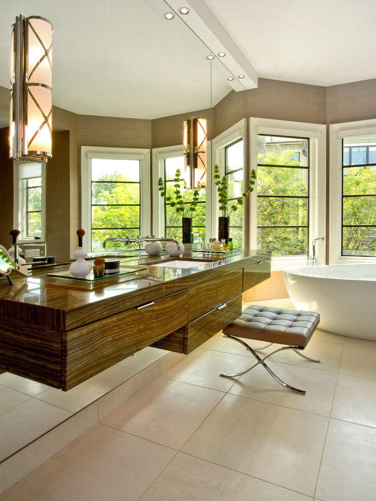Bild på ett stort funkis en-suite badrum, med ett fristående badkar, släta luckor, skåp i mörkt trä, beige väggar, klinkergolv i keramik, ett undermonterad handfat och träbänkskiva