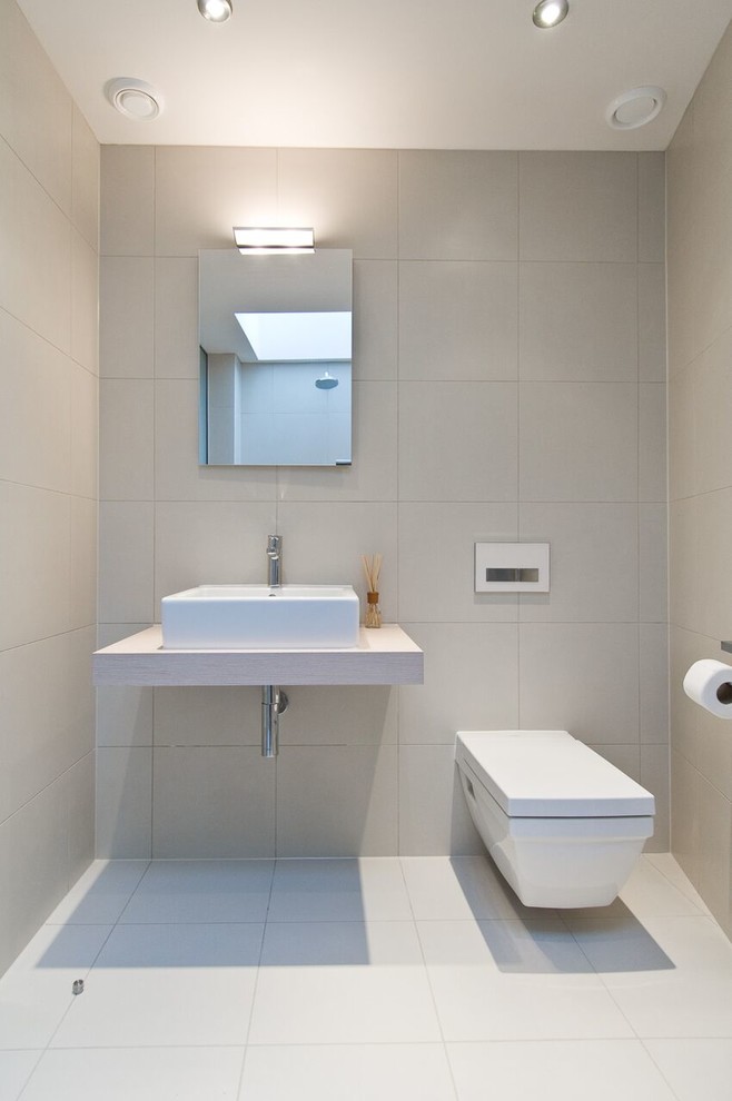Idéer för att renovera ett mellanstort funkis badrum, med en vägghängd toalettstol, grå väggar, ett väggmonterat handfat och grått golv