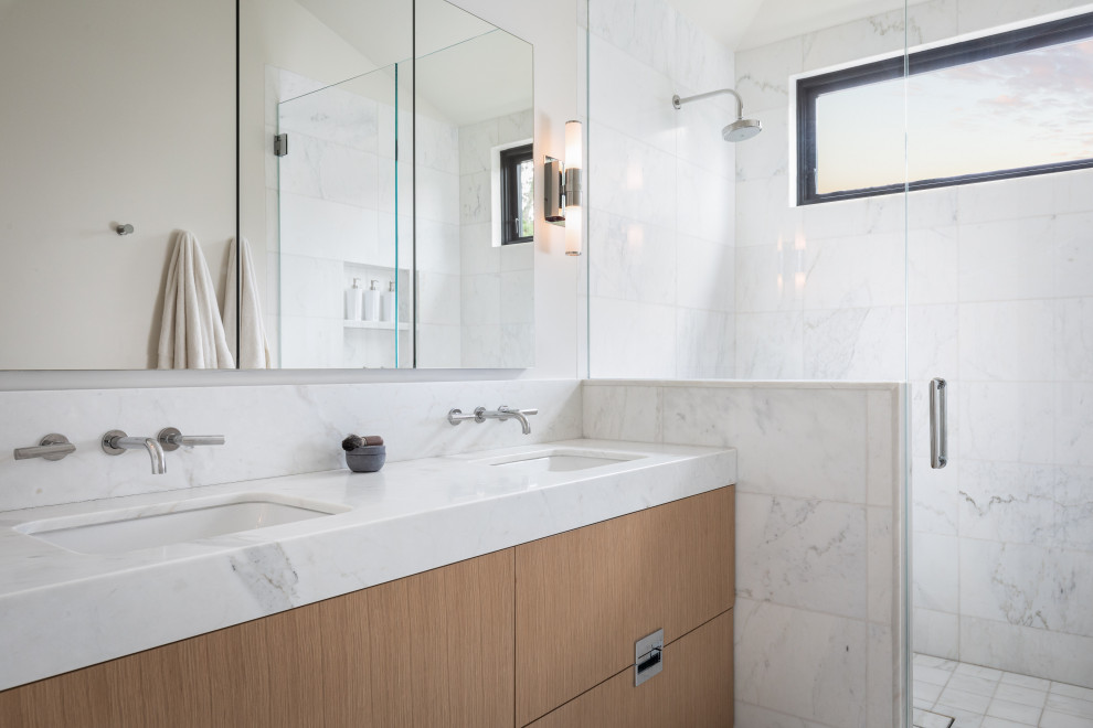 Пример оригинального дизайна: главная ванная комната среднего размера в современном стиле с фасадами с декоративным кантом, коричневыми фасадами, открытым душем, унитазом-моноблоком, белой плиткой, плиткой из листового камня, белыми стенами, полом из керамической плитки, врезной раковиной, мраморной столешницей, белым полом, душем с распашными дверями, белой столешницей, тумбой под две раковины, встроенной тумбой и сводчатым потолком