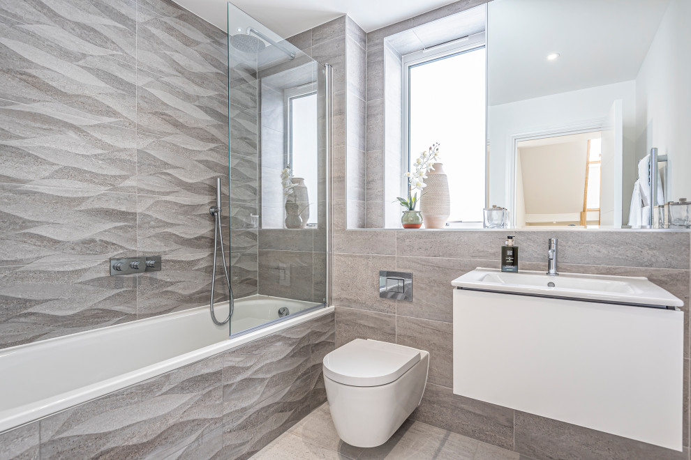 Immagine di una stanza da bagno minimal con ante lisce, ante bianche, vasca ad alcova, WC sospeso, piastrelle grigie, lavabo a consolle e pavimento grigio