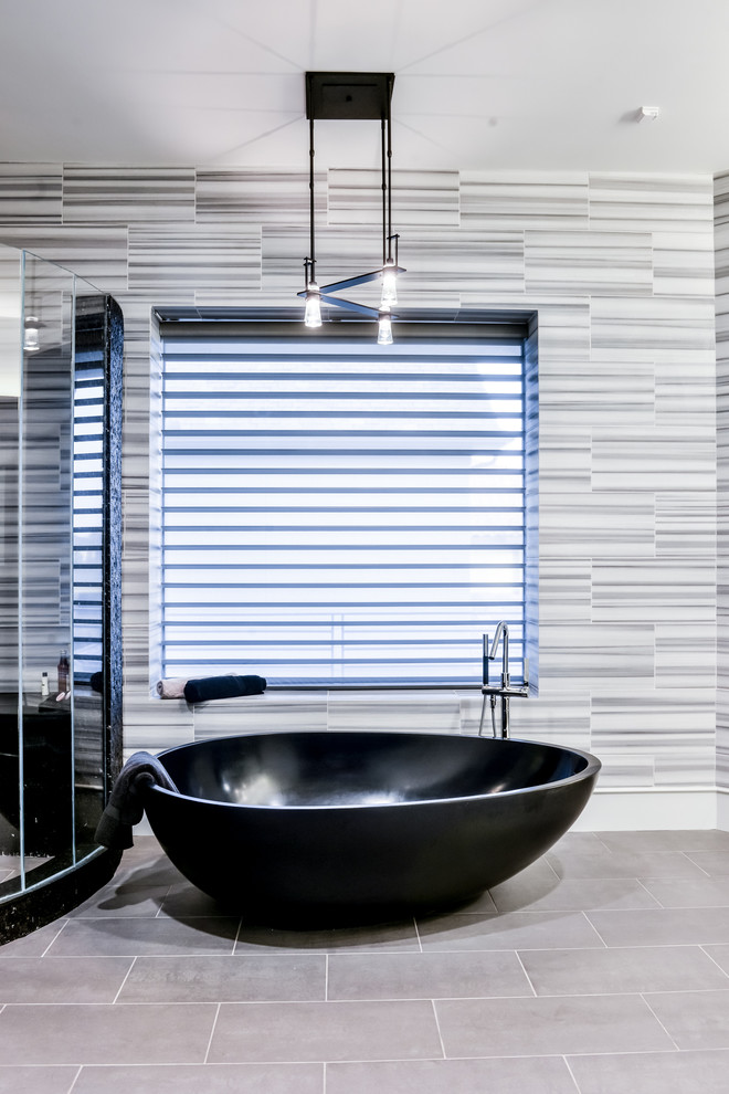 Foto på ett stort funkis en-suite badrum, med ett fristående badkar, en hörndusch, grå kakel, marmorkakel, grått golv och dusch med gångjärnsdörr