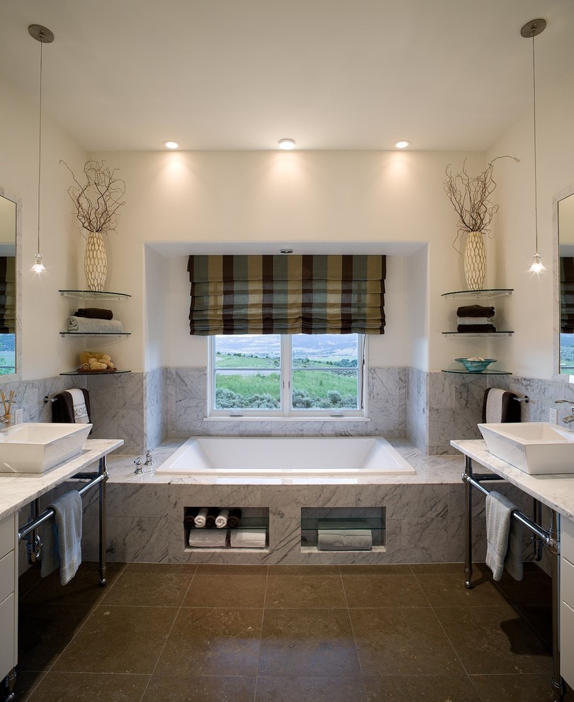 Inspiration for a classic bathroom in Denver with flat-panel cabinets, white cabinets, marble worktops, a built-in bath, a vessel sink, beige walls, grey tiles, porcelain tiles, ceramic flooring, brown floors and white worktops.