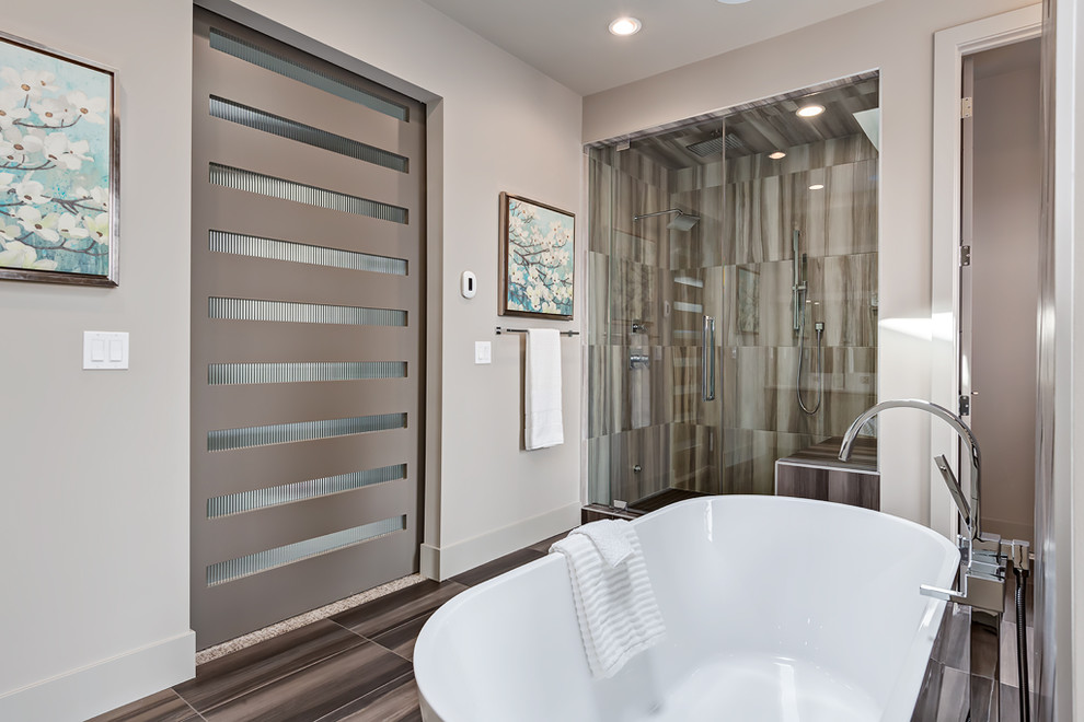 Immagine di una stanza da bagno padronale contemporanea con vasca freestanding, piastrelle marroni e pareti grigie