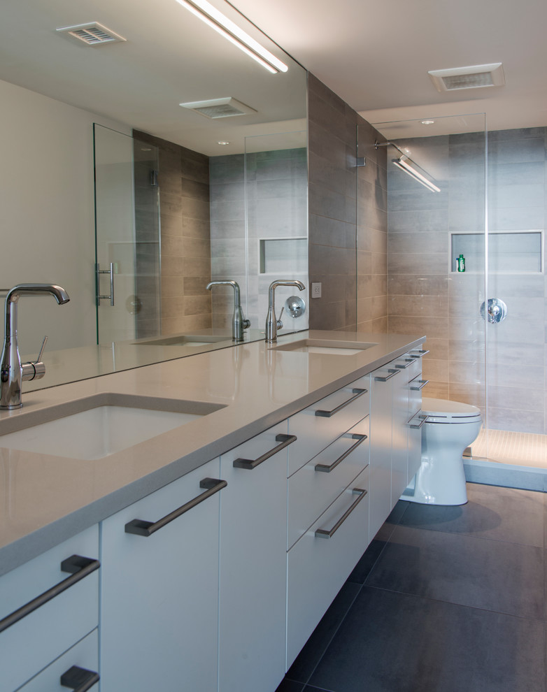 This is an example of a medium sized contemporary ensuite bathroom in DC Metro with flat-panel cabinets, white cabinets, brown tiles, porcelain tiles, beige walls, porcelain flooring, a submerged sink, engineered stone worktops, brown floors and an open shower.