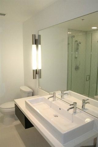 Свежая идея для дизайна: большая главная ванная комната в современном стиле с плоскими фасадами, темными деревянными фасадами, отдельно стоящей ванной, угловым душем, унитазом-моноблоком, зеленой плиткой, стеклянной плиткой, белыми стенами, полом из керамической плитки, раковиной с несколькими смесителями и столешницей из искусственного камня - отличное фото интерьера