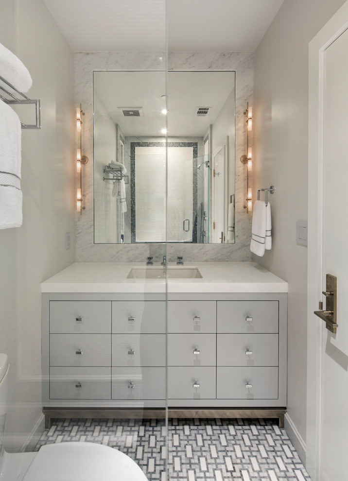 Пример оригинального дизайна: ванная комната среднего размера в современном стиле с плоскими фасадами, серыми фасадами, ванной в нише, душем над ванной, унитазом-моноблоком, серой плиткой, белой плиткой, цементной плиткой, серыми стенами, полом из цементной плитки, душевой кабиной, врезной раковиной, мраморной столешницей, разноцветным полом и открытым душем