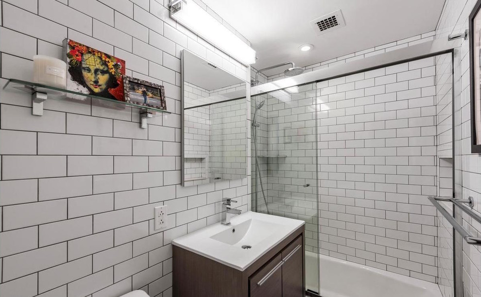 Foto på ett mellanstort vintage badrum, med släta luckor, skåp i mörkt trä, ett badkar i en alkov, en dusch i en alkov, vit kakel, tunnelbanekakel, ett integrerad handfat, bänkskiva i akrylsten och dusch med skjutdörr