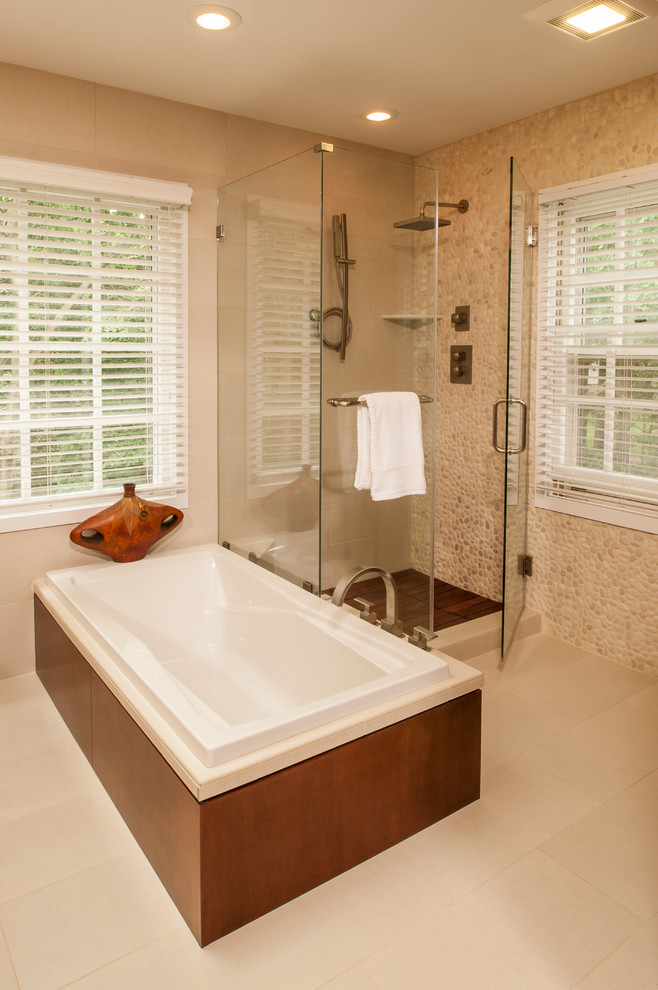 Ejemplo de cuarto de baño principal actual grande con puertas de armario marrones, encimera de acrílico, bañera exenta, ducha esquinera y baldosas y/o azulejos beige