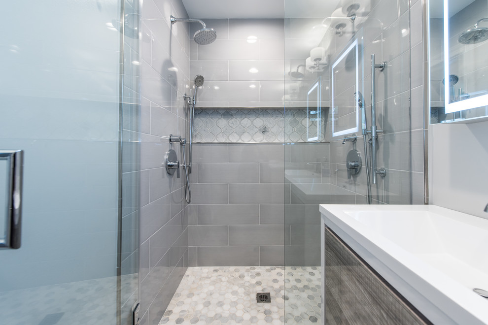 Example of a small trendy master gray tile and subway tile double shower design in DC Metro with flat-panel cabinets, distressed cabinets, gray walls, a console sink, solid surface countertops and a hinged shower door