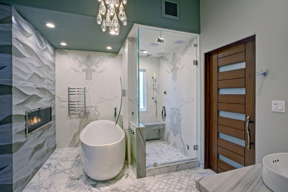 На фото: огромная главная ванная комната в современном стиле с отдельно стоящей ванной, душем в нише, серой плиткой, серыми стенами, мраморной столешницей, серым полом, душем с распашными дверями и сиденьем для душа
