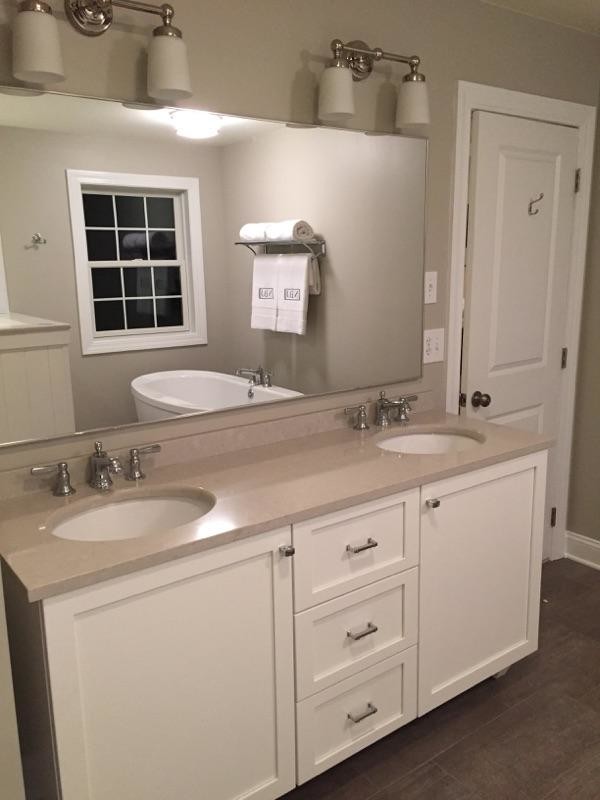 Large contemporary ensuite bathroom in Boston with a submerged sink, recessed-panel cabinets, white cabinets, a freestanding bath, brown walls, medium hardwood flooring, an alcove shower, a two-piece toilet, white tiles and engineered stone worktops.