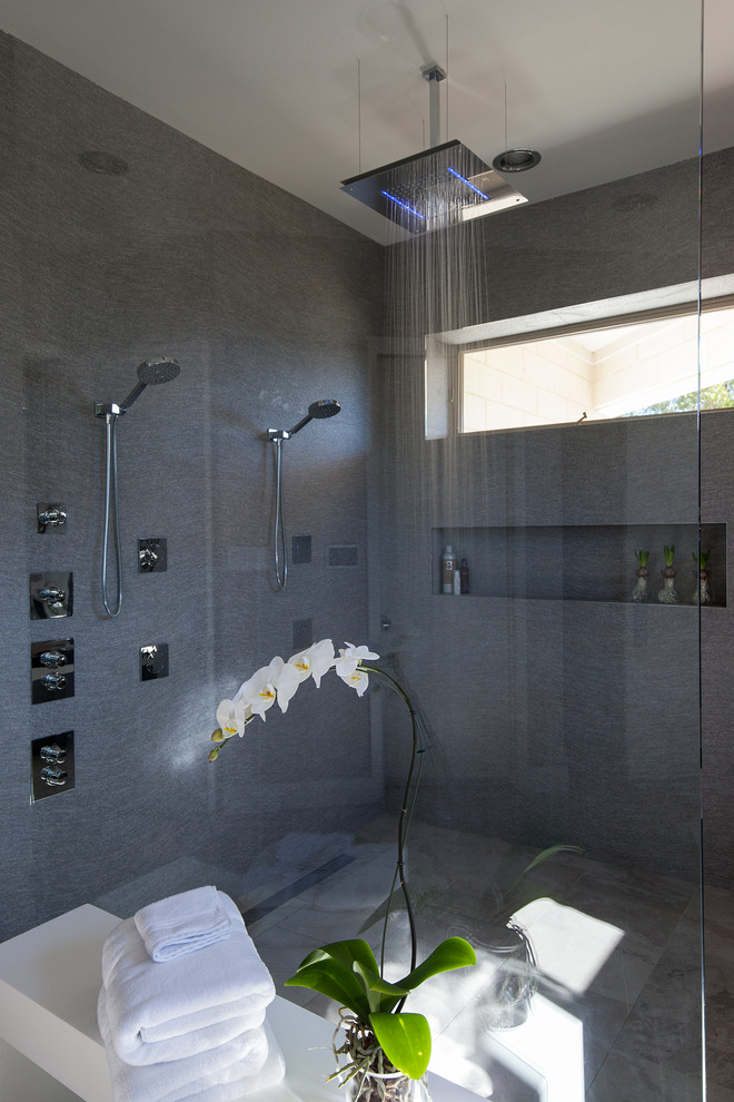 Medium sized contemporary ensuite bathroom in Dallas with open cabinets, grey cabinets, a freestanding bath, a walk-in shower, grey tiles, multi-coloured tiles, mirror tiles, grey walls, ceramic flooring, an integrated sink and solid surface worktops.