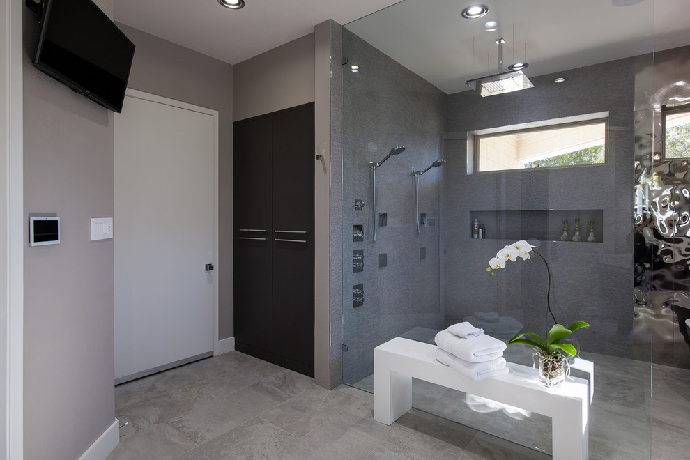 Photo of a medium sized contemporary ensuite bathroom in Dallas with open cabinets, grey cabinets, a freestanding bath, a walk-in shower, grey tiles, multi-coloured tiles, mirror tiles, grey walls, ceramic flooring, an integrated sink and solid surface worktops.