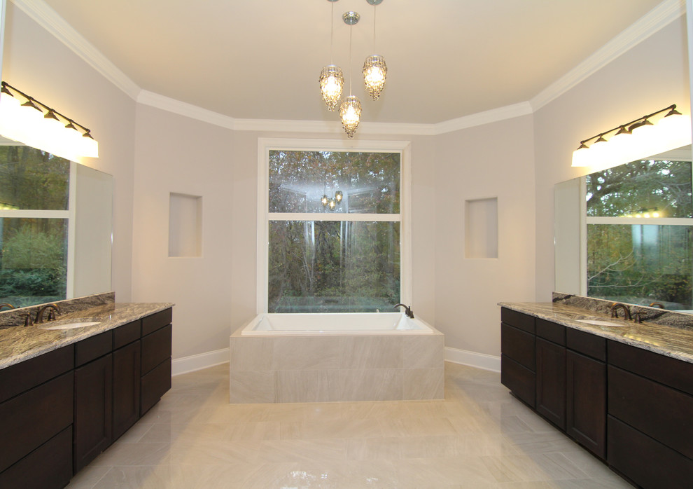 Example of a huge classic master white tile and ceramic tile ceramic tile drop-in bathtub design in Raleigh with an undermount sink, flat-panel cabinets, dark wood cabinets, granite countertops, a one-piece toilet and gray walls