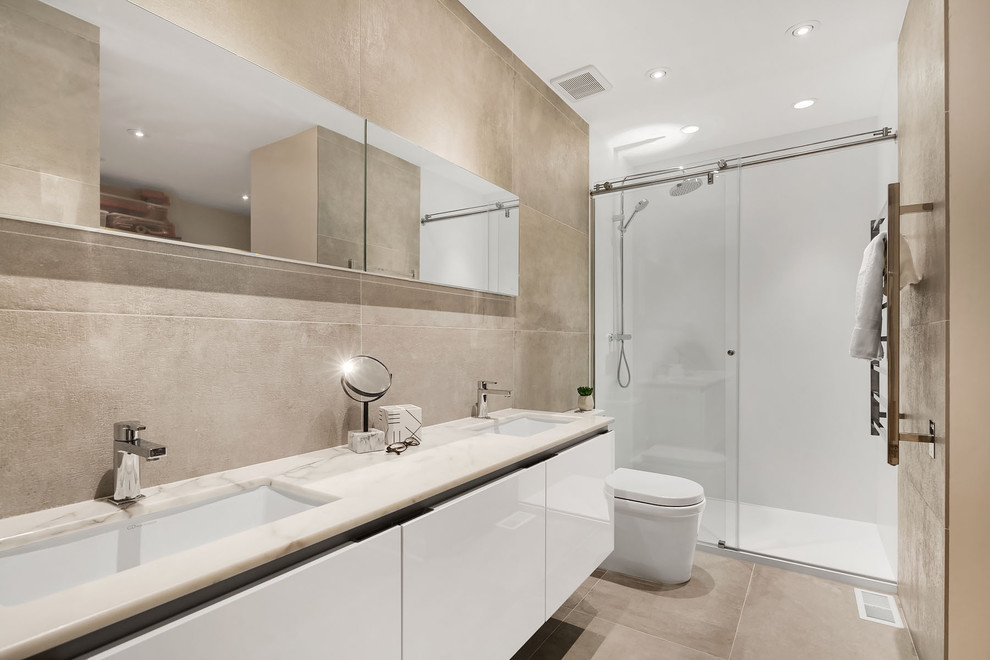 Idéer för ett mellanstort modernt badrum med dusch, med släta luckor, vita skåp, en dusch i en alkov, en toalettstol med hel cisternkåpa, beige väggar, ett nedsänkt handfat, beiget golv och dusch med skjutdörr